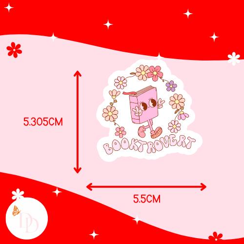 Sticker with a cartoon character and 'Booktrotter' text on a red and pink background with measurements. The sticker is 5.305cm tall and 5.5cm wide.