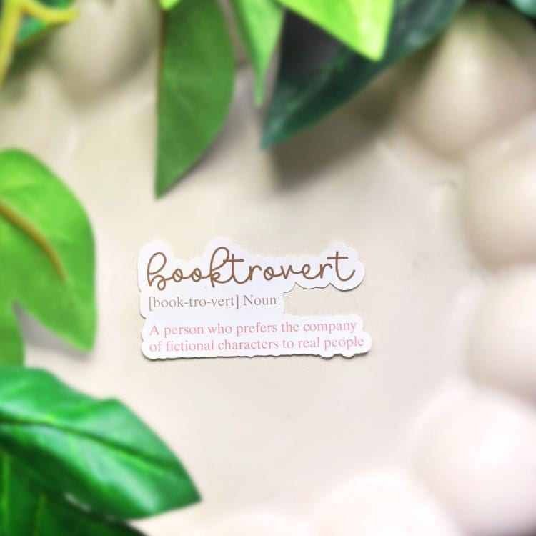 Definition sticker of 'booktrovert' with green leaves in the background. Not an official definition, 