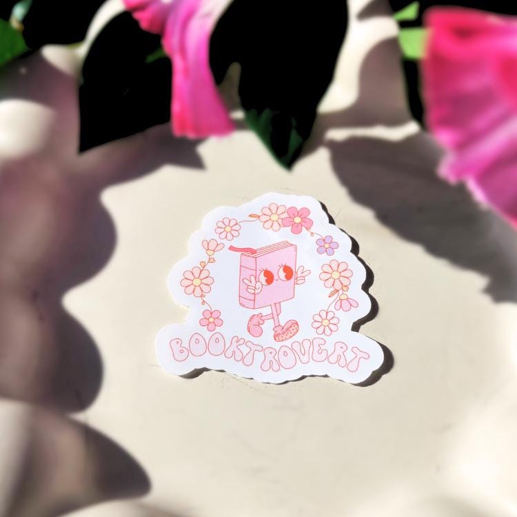 Sticker with a cartoon book character and flowers on a light background