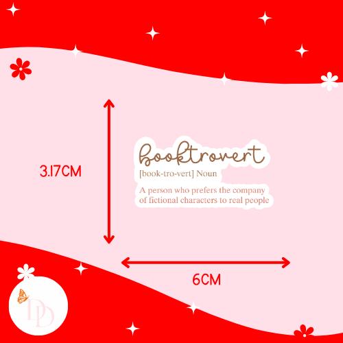 Measurement chart with 'booktrovert' definition sticker and dimensions on a red and pink background. The sticker is 3.17cm high and 6cm wide. 